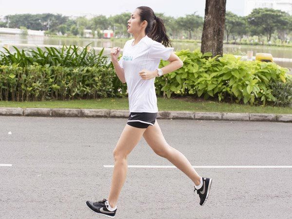 Người phụ nữ chạy bộ trên đường trong công viên.